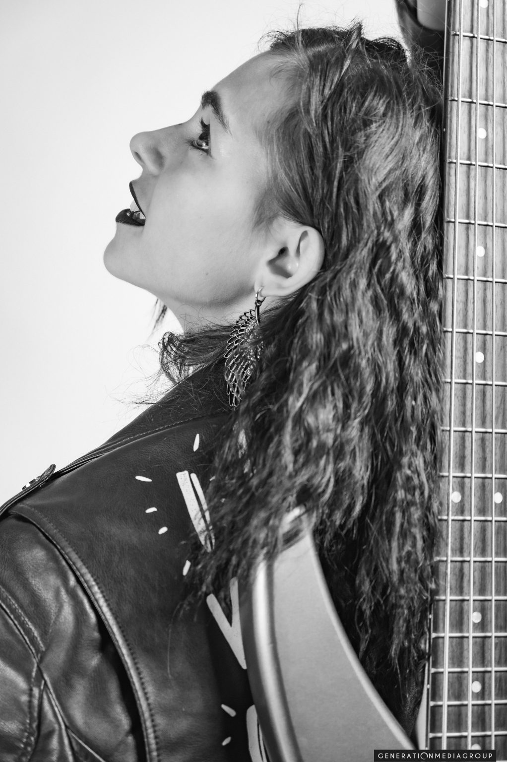 Portrait Photography of a young white femle model posing with a bass guitar