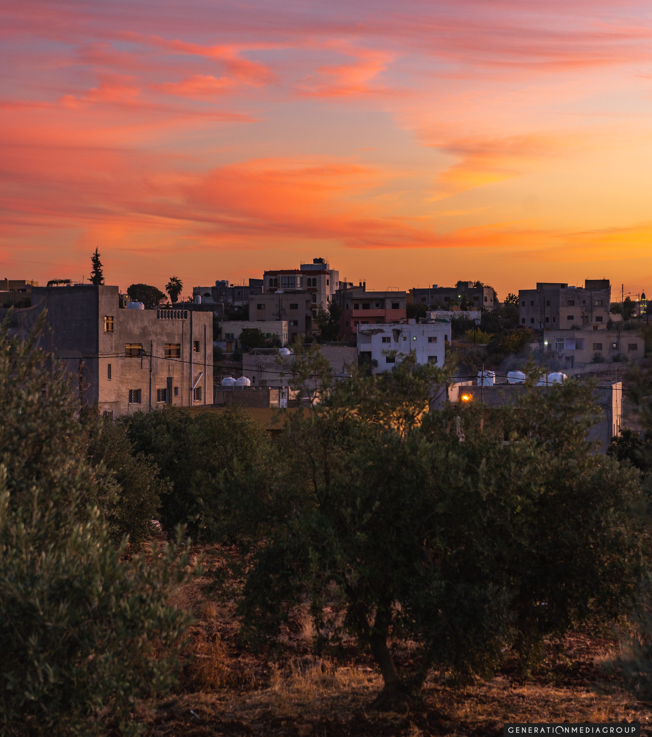 Landscape travel photograph of a small town in the middle east with a orange sunset